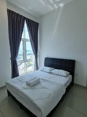 a bedroom with a large bed with a window at Southbay Seaview Condo A10 #10minQueensbay #15minSPICE in Bayan Lepas