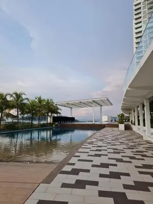 a swimming pool with palm trees and a building at Southbay Seaview Condo A10 #10minQueensbay #15minSPICE in Bayan Lepas