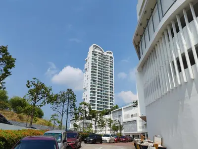 a tall white building with cars parked in a parking lot at Southbay Seaview Condo A10 #10minQueensbay #15minSPICE in Bayan Lepas
