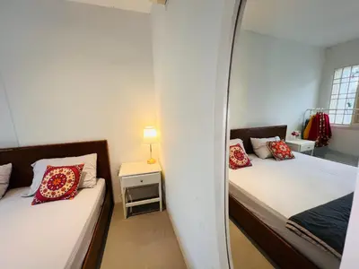 two beds in a small room with a mirror at Georgetown Kyash House 23 in George Town
