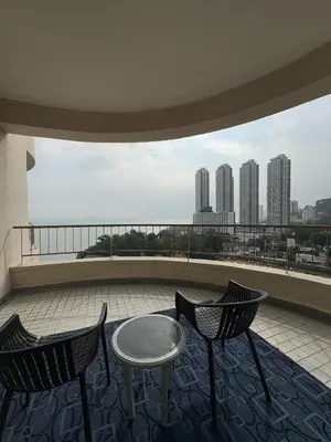 two chairs and a table on a balcony with a view at 17 Jazz sweet beachfront resort in Tanjung Bungah