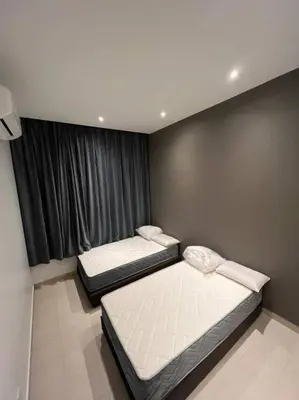 two beds in a room with a window at Villa 8812 \u6781\u7b80\u98ce\u6c11\u5bbf \u8212\u9002\u73b0\u4ee3\u98ce in Kampong Sungai Udang