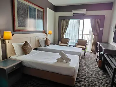 a hotel room with two beds and a television at Seaview Deluxe Rainbow Paradise Tg Bungah 6pax in Tanjung Bungah