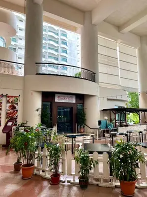a lobby with potted plants in front of a building at Seaview Deluxe Rainbow Paradise Tg Bungah 6pax in Tanjung Bungah