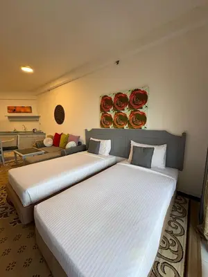 a hotel room with two beds and a couch at Seaview Deluxe Rainbow Paradise Tg Bungah 6pax in Tanjung Bungah