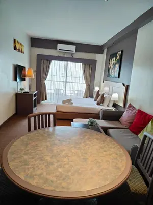 a hotel room with a table and a bed at Seaview Deluxe Rainbow Paradise Tg Bungah 6pax in Tanjung Bungah