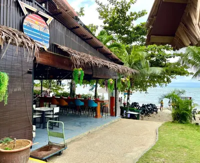 a restaurant on the beach with tables and chairs at Seaview Deluxe Rainbow Paradise Tg Bungah 6pax in Tanjung Bungah