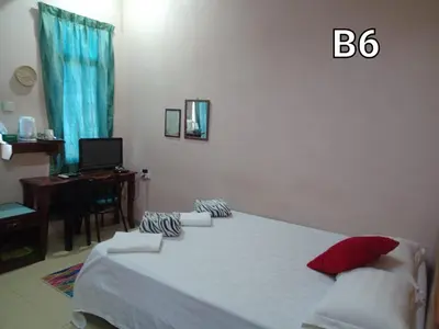 a bedroom with a bed and a desk with a computer at Hotel Muallim Tanjung Malim in Tanjung Malim
