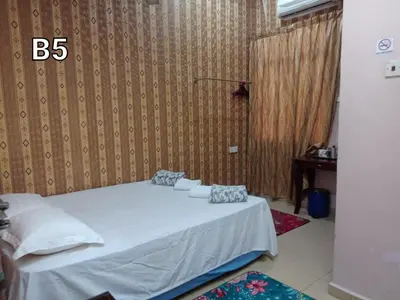 a bedroom with a white bed with pillows on it at Hotel Muallim Tanjung Malim in Tanjung Malim