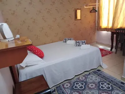 a bedroom with a white bed with red pillows on it at Hotel Muallim Tanjung Malim in Tanjung Malim