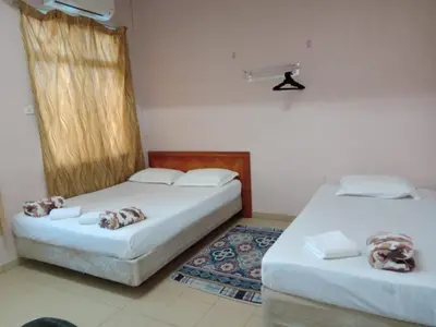two beds sitting in a room withermottermott at Hotel Muallim Tanjung Malim in Tanjung Malim