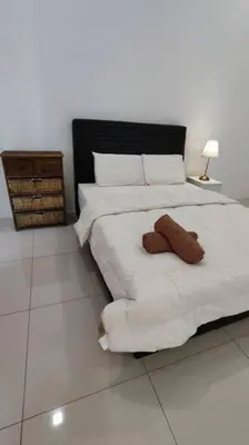 a bedroom with a large white bed with two pillows at Ipoh Sunway Tambun Spacious Homestay in Ipoh
