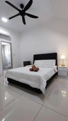 a bedroom with a large bed with a ceiling fan at Ipoh Sunway Tambun Spacious Homestay in Ipoh