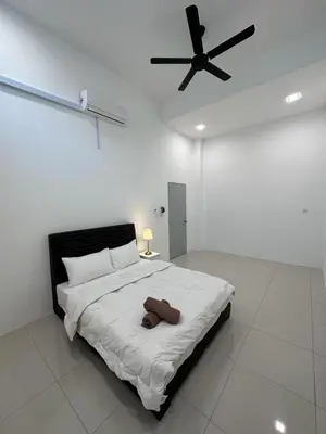 a bedroom with a large bed with a ceiling fan at Ipoh Sunway Tambun Spacious Homestay in Ipoh