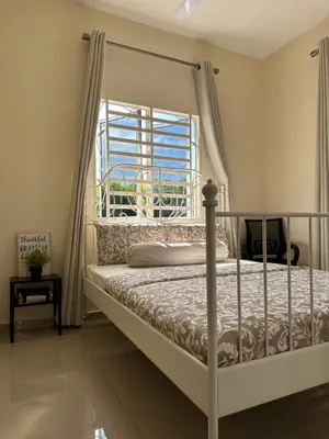 a bedroom with a bed and a window at DeAsmarra Homestay in Tanjung Piandang