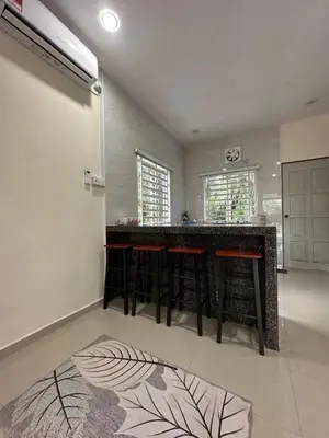 a kitchen with a bar with stools in a room at DeAsmarra Homestay in Tanjung Piandang