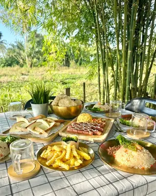 a table with many plates of food on it at DeAsmarra Homestay in Tanjung Piandang