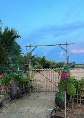 a fence with flowers and plants in a field at DeAsmarra Homestay in Tanjung Piandang