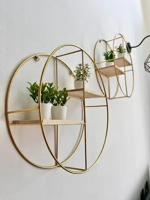 a gold circle shelf with potted plants on a wall at Aloft Cameron Highlands B in Brinchang