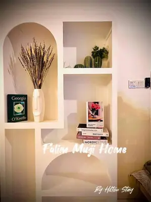 a room with a shelf with a vase and books at Muji Home Falim in Ipoh