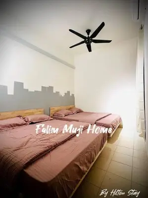 a bedroom with a bed with a ceiling fan at Muji Home Falim in Ipoh