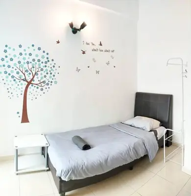 a bedroom with a bed with a tree and birds on the wall at Comfy Home Near to SPICE and USM in Bayan Lepas