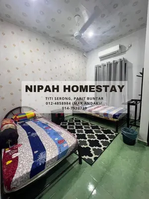 a room with two beds and a sign that reads nirvana homesstay at Nipah Homestay Parit Buntar in Parit Buntar