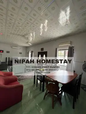 a room with a table and chairs and a sign on the ceiling at Nipah Homestay Parit Buntar in Parit Buntar