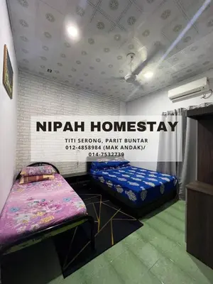a room with two beds and a sign that reads nirvana homestay at Nipah Homestay Parit Buntar in Parit Buntar