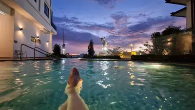 a dog swimming in a swimming pool at night at H&W Sunway Onsen Suites Services Tambun Ipoh S-07-05 in Ipoh