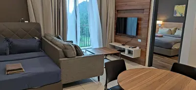 a living room with a couch and a bed and a table at H&W Sunway Onsen Suites Services Tambun Ipoh S-07-05 in Ipoh