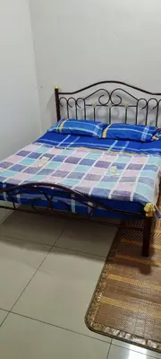a bed with a checkered blanket sitting on the floor at D'HutHomestay Puncak Iskandar in Seri Iskandar