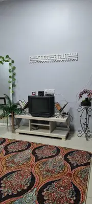 a living room with a television and a rug at D'HutHomestay Puncak Iskandar in Seri Iskandar