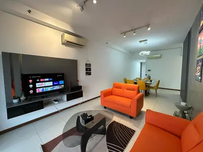 a living room with orange chairs and a flat screen tv at NEW 4Queen Bed 3 Room 2CP near Gurney with tvbox and KTV Set in Tanjong Tokong