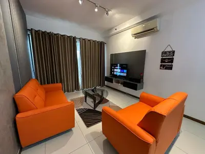 a living room with two orange chairs and a flat screen tv at NEW 4Queen Bed 3 Room 2CP near Gurney with tvbox and KTV Set in Tanjong Tokong