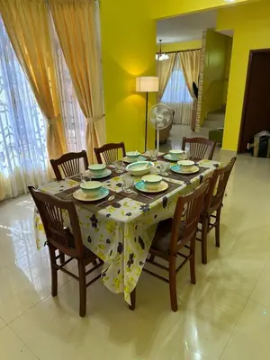 a dining room table with chairs and a tablecloth on it at GS HOMESTAY WHOLE VILLA in Bayan Lepas