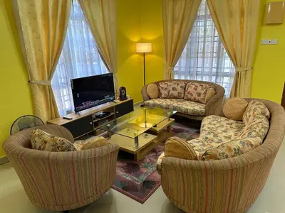 a living room with two chairs and a tv at GS HOMESTAY WHOLE VILLA in Bayan Lepas