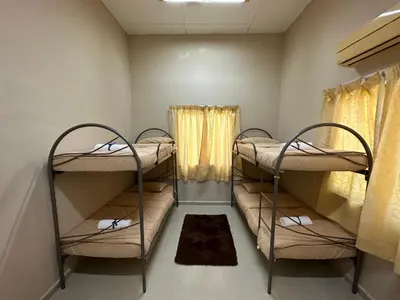 a room with two bunk beds and a window at GS HOMESTAY WHOLE VILLA in Bayan Lepas