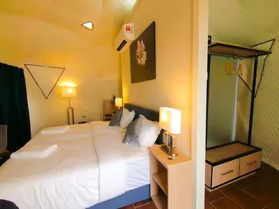 a bedroom with a large white bed and two lamps at The Dome @ Gua Musang in Gua Musang