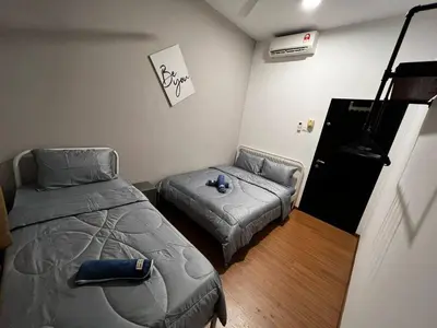 a small bedroom with a bed and a couch at Ipoh Cozy Modern Suite 6-7pax @ Adson's Home in Ipoh