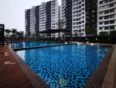 a large blue swimming pool in front of tall buildings at Ipoh Cozy Modern Suite 6-7pax @ Adson's Home in Ipoh
