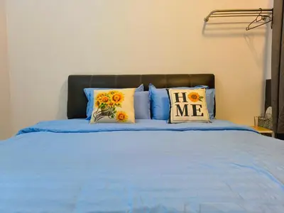 a bed with blue sheets and sunflower pillows on it at New The Sun Homestay at Sg Nibong nearby Queensbay or PISA or FTZ Bayan Lepas HENG in Bayan Lepas