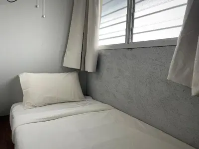 a bed in a room with a window at GRAYHAUS INN Ipoh in Ipoh