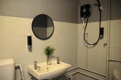 a bathroom with a sink and a mirror and a toilet at GRAYHAUS INN Ipoh in Ipoh