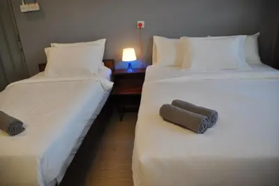 two beds sitting next to each other in a room at GRAYHAUS INN Ipoh in Ipoh
