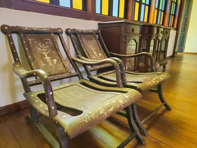 two old chairs sitting in a room with books at The Century Hotel George Town \u4e54\u6cbb\u5e02\u4e16\u7eaa\u9152\u5e97 in George Town