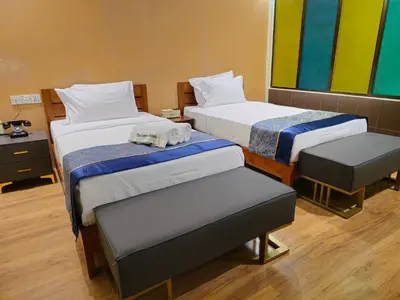 a hotel room with two beds and a chair at The Century Hotel George Town \u4e54\u6cbb\u5e02\u4e16\u7eaa\u9152\u5e97 in George Town