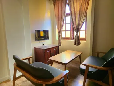 a living room with two chairs and a table and a tv at The Century Hotel George Town \u4e54\u6cbb\u5e02\u4e16\u7eaa\u9152\u5e97 in George Town