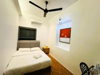 a bedroom with a bed and a tv on the wall at The Century Aigoh Hotel in George Town