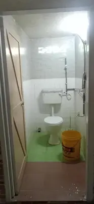 a bathroom with a toilet and a bucket in it at Kurnia Homestay in Slim River
